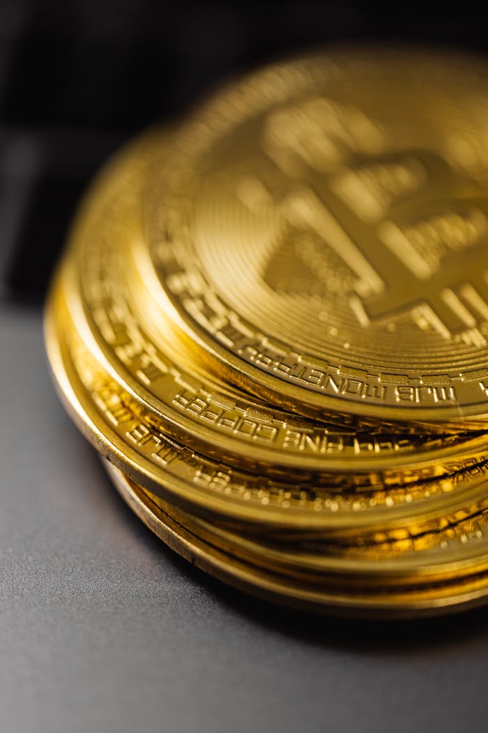 Close-up of a stack of shiny gold bitcoins on a computer keyboard, symbolizing digital currency.